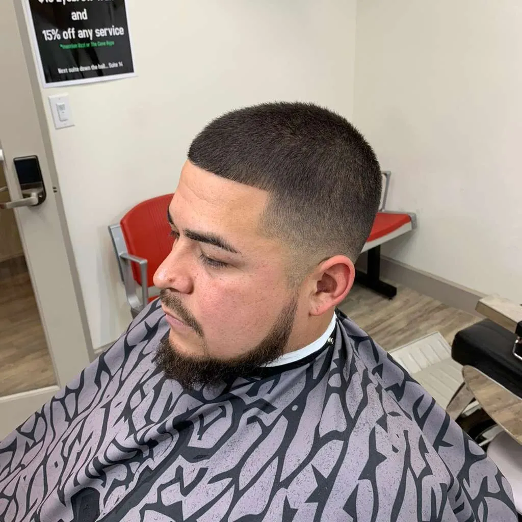Short buzz cut with a low skin fade and a lined beard, cut at The Cave Hype in North Phoenix