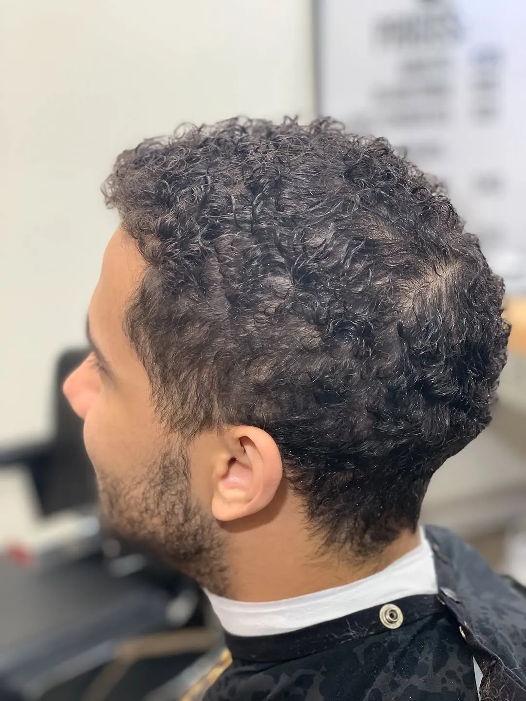 Taper on curly hair with a razor lineup, cut at The Cave Hype