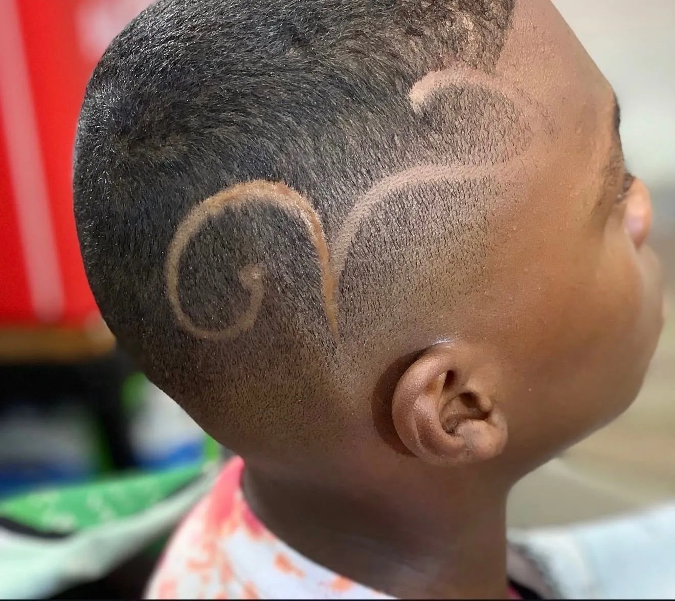 Kid's cut with freehand curved hair designs and a taper, cut at The Cave Hype in North Phoenix