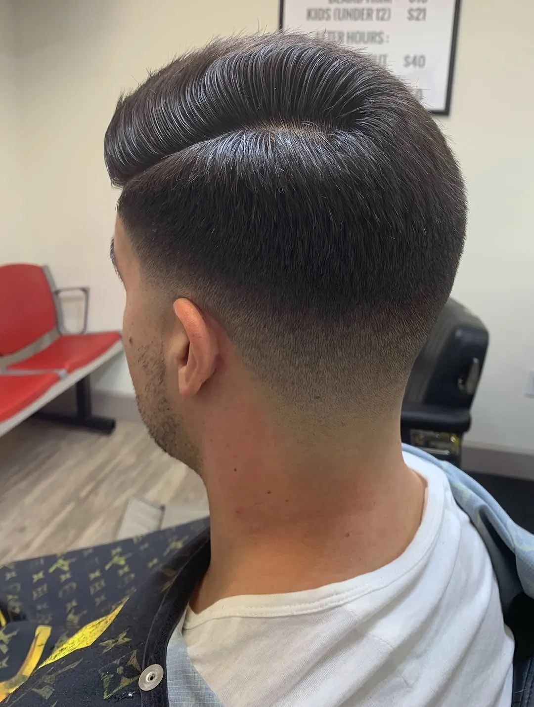 High volume pompadour over a clean mid fade, cut at The Cave Hype