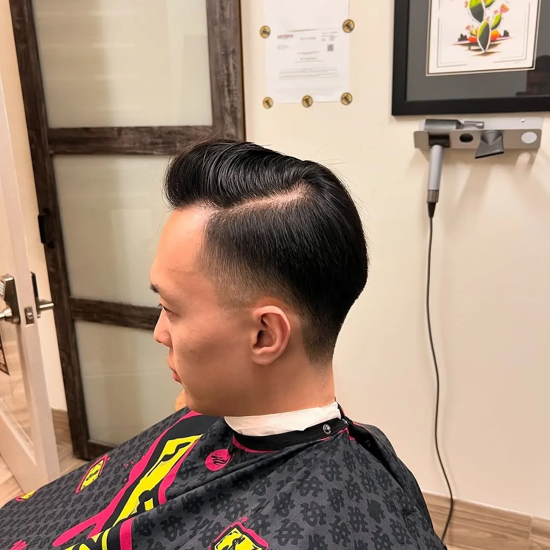 Side part with a sharp skin fade, cut at The Cave Hype